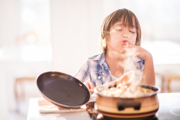 Foto cute adorável menino na cozinha