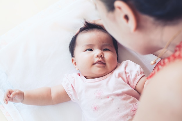 Cute, asian newborn bebê menina, tocando, com, mãe