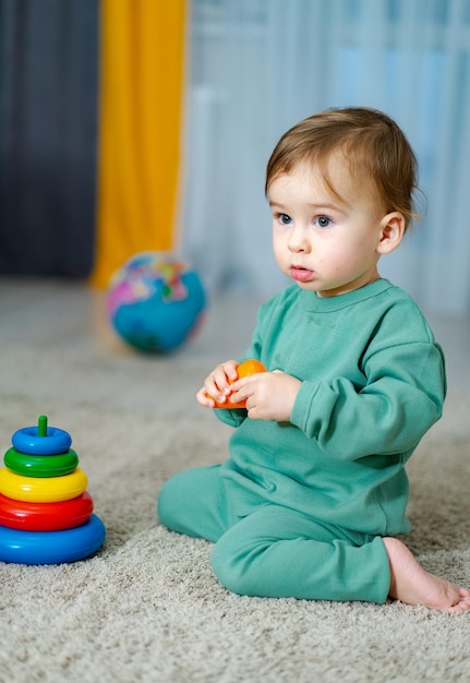 Cute Baby spielt mit bunten Regenbogen-Spielzeug-Pyramide Spielzeug für kleine Kinder Interieur für Kinderzimmer für kleine Jungen Kind mit pädagogischem Spielzeug Frühe Entwicklung