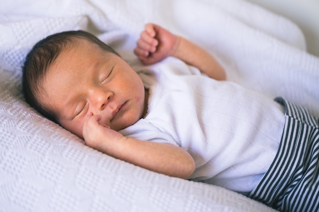 Cute bebê recém-nascido dorme em branco