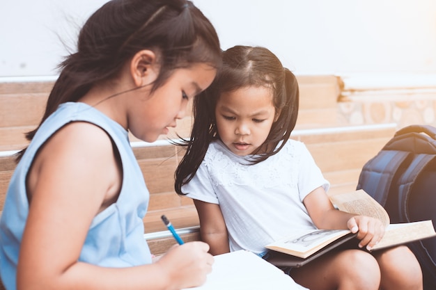 Cute, criança asiática, menina, e, dela, irmã, lendo um livro, junto, com, divertimento, e, felicidade