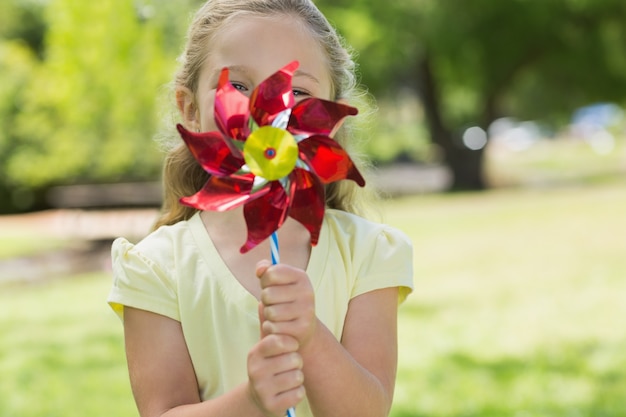 Cute girl holding pinwheel at park