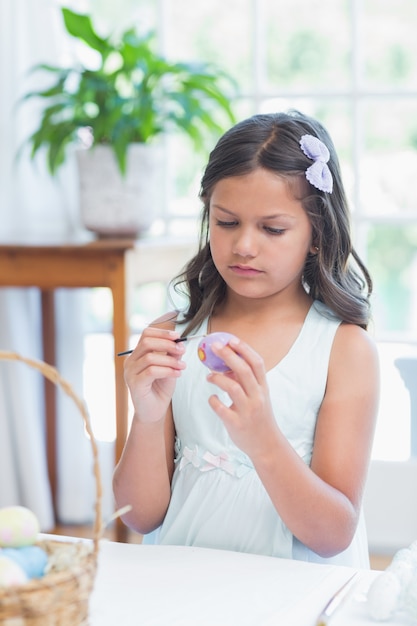 Cute girl painting easter eggs