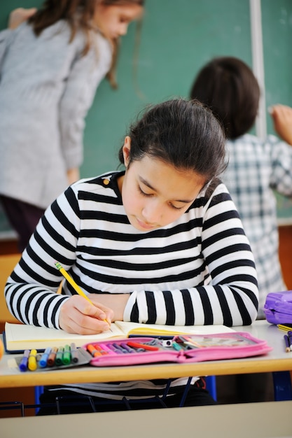 Cute girl writing in school school