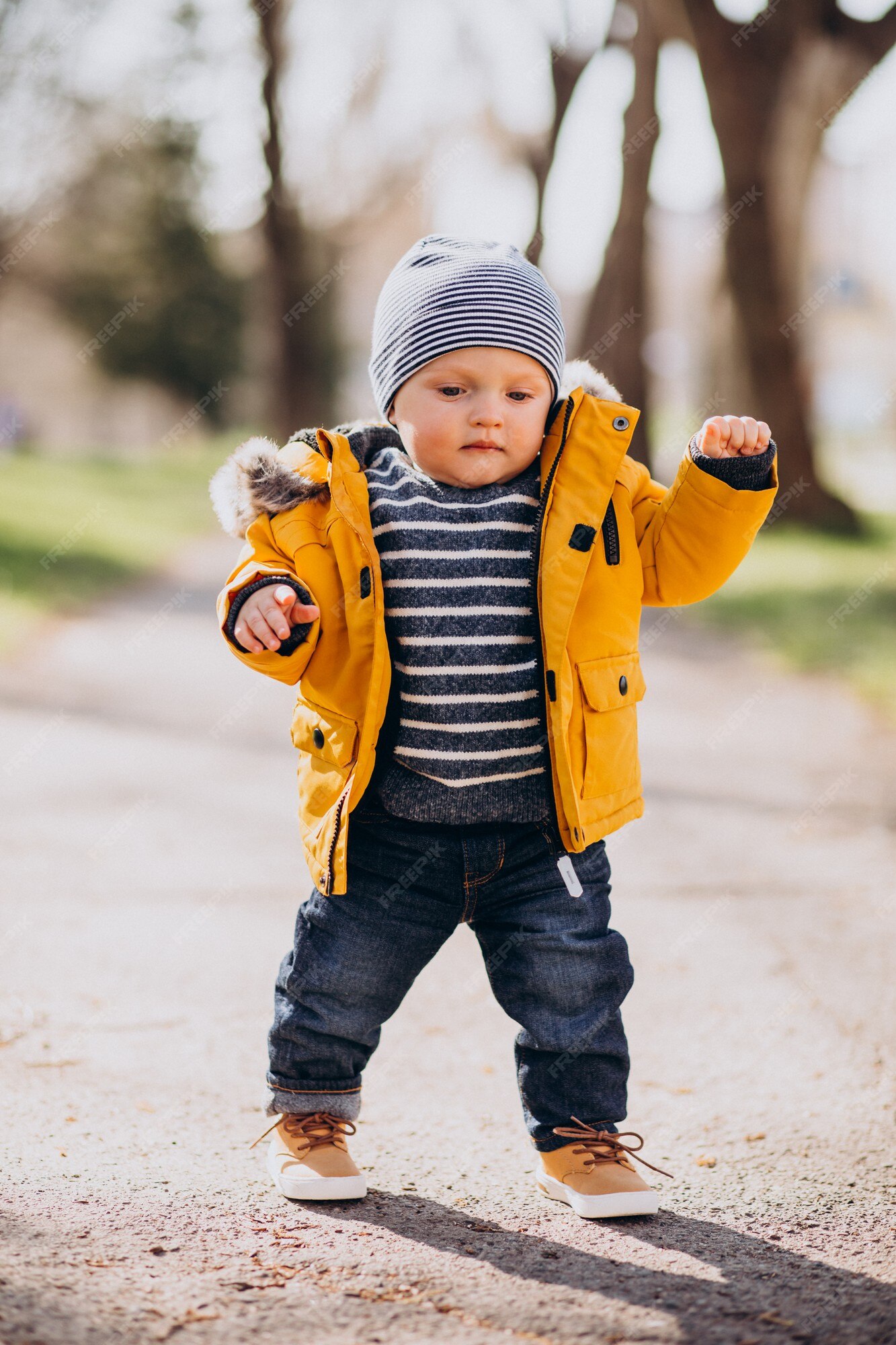 Cute little boy en chaqueta amarilla haciendo los primeros de | Premium