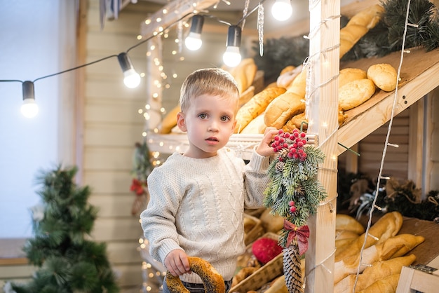 Cute little boy en una escalera en una panadería