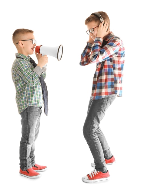 Cute little boy ignorando a su amigo con megáfono, en blanco