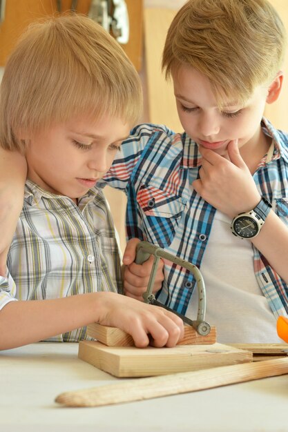 Cute little boys trabajando con madera en el taller