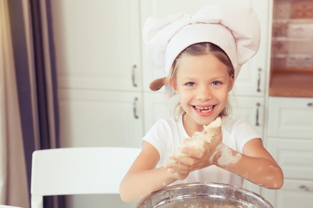 Cute Little Girl cocinar pastel de manzana para la cena Kid prepara la masa en casa