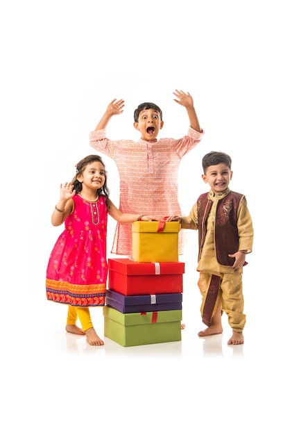 Cute Little Indian Kids con cajas de regalo, que se encuentran aisladas sobre fondo blanco.