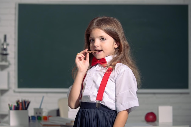 Cute little school kid girl estudio en un aula Primer día en la escuela