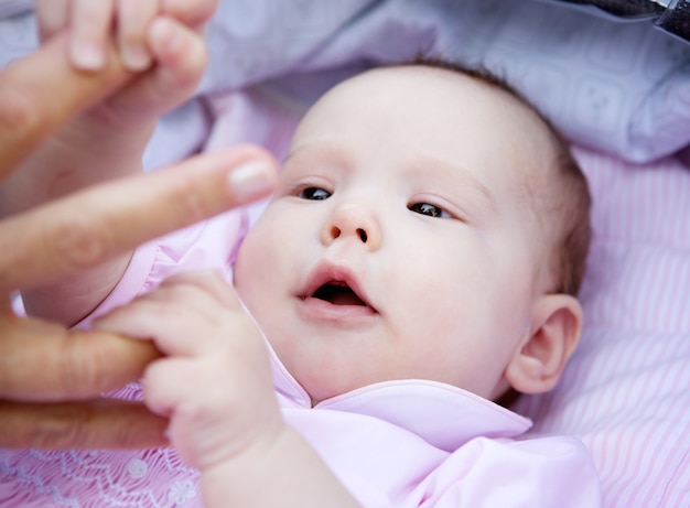 Cute, menina bebê, segurando, pai, mãos