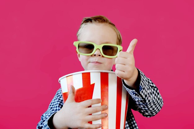 Foto cute spaß kind baby junge 4 jahre alt in rotem t-shirt hält eimer für popcorn