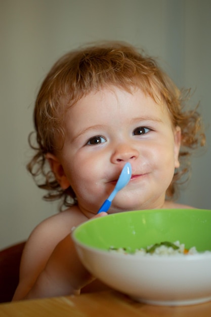 Cutr bebê criança comendo-se com uma colher