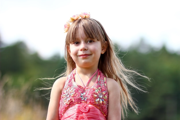 Cutr niña en un vestido cerca del campo