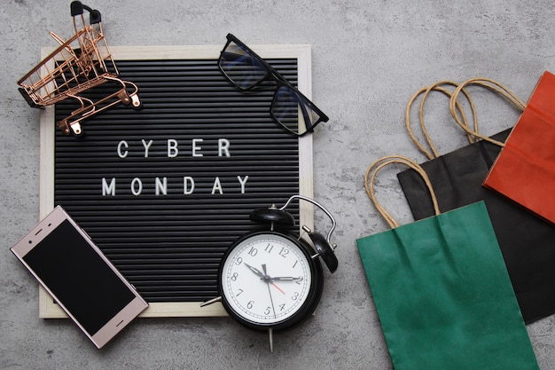 Cyber Monday, texto plano de venta laico en tablero de cartas con reloj despertador, buena bolsa de regalos y gadget