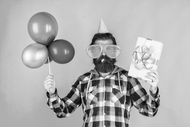 Cyber segunda-feira feliz aniversário para você homem barbudo celebração do feriado masculino com balões de festa e caixa de presente barba por fazer homem brutal com barba celebrar o sucesso nos negócios expressar pura felicidade