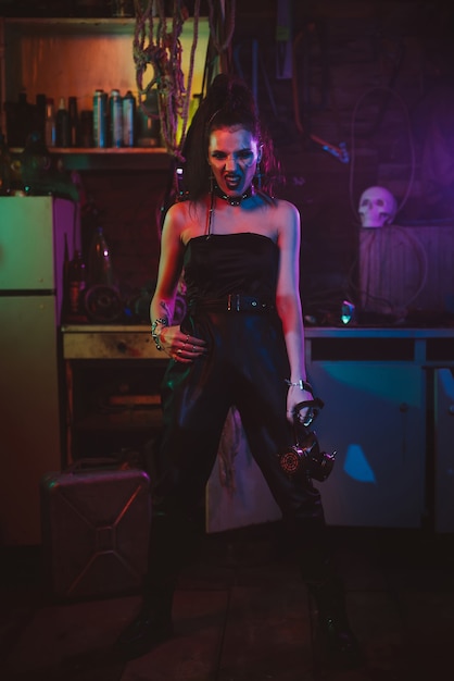 Cyberpunk-Cosplay. Mädchen in einem futuristischen Kostüm-Cosplay-Steampunk-Stil. Eine Frau mit Neonlicht in einer postapokalyptischen Garage