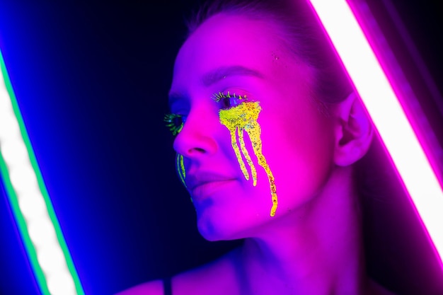 Foto cyberpunk girl con maquillaje estilizado a la luz de las lámparas de neón