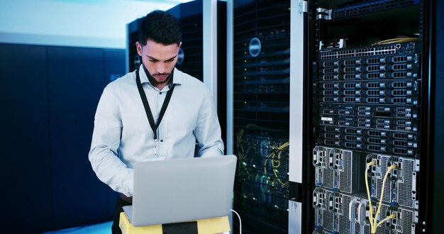 Cybersecurity upgrade and man with laptop coding or check server performance and network engineer Data center IT specialist and person with tech for software update power cables and electricity