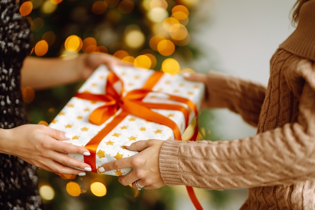 Da el regalo Intercambiando el regalo de Navidad Mujer joven da un regalo en una caja