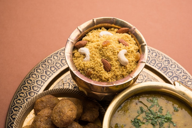 Daal baati churma é um alimento saudável popular do rajastão, na índia. servido em louças brancas sobre fundo temperamental.