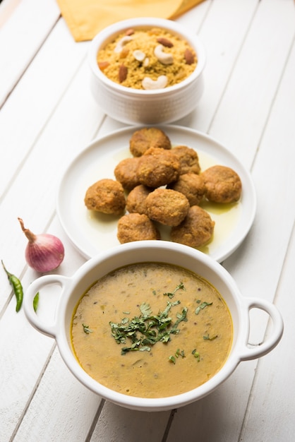 Daal Baati Churma é um alimento saudável popular do Rajastão, na Índia. Servido em louças brancas sobre fundo temperamental.