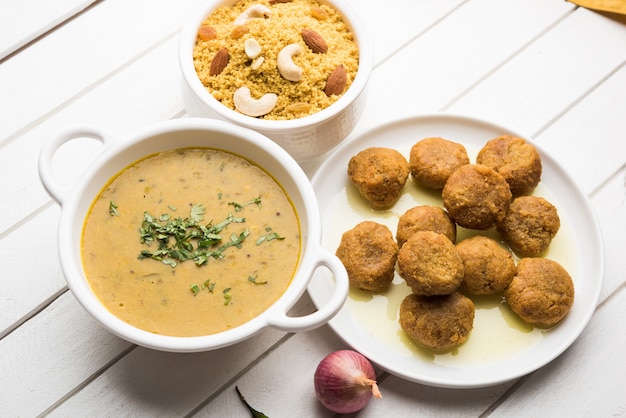 Daal Baati Churma é um alimento saudável popular do Rajastão, na Índia. Servido em louças brancas sobre fundo temperamental.