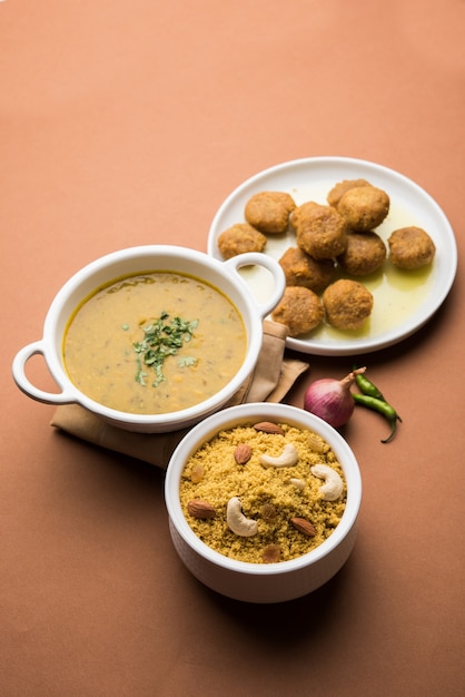 Daal Baati Churma es un alimento saludable popular de Rajasthan, India. Servido en vajilla blanca sobre fondo de mal humor.