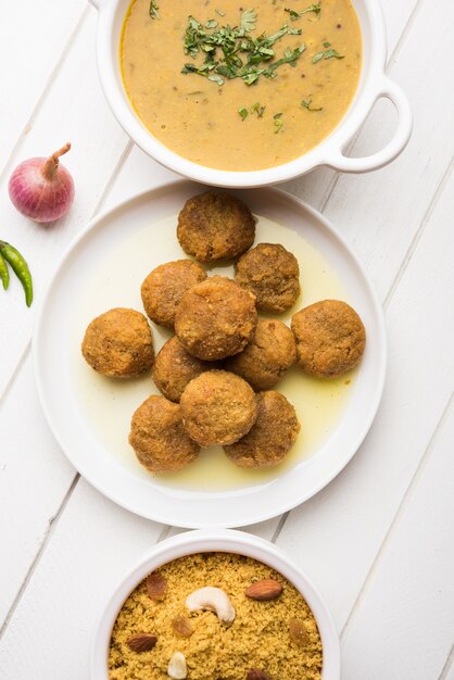 Daal Baati Churma ist ein beliebtes gesundes Essen aus Rajasthan, Indien. Serviert in weißem Geschirr über stimmungsvollem Hintergrund.