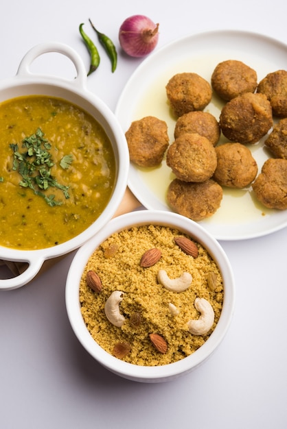 Daal Baati Churma ist ein beliebtes gesundes Essen aus Rajasthan, Indien. Serviert in weißem Geschirr über stimmungsvollem Hintergrund.