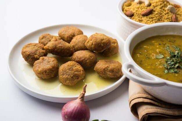 Foto daal baati churma ist ein beliebtes gesundes essen aus rajasthan, indien. serviert in weißem geschirr über stimmungsvollem hintergrund.