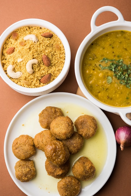 Daal Baati Churma ist ein beliebtes gesundes Essen aus Rajasthan, Indien. Serviert in weißem Geschirr über stimmungsvollem Hintergrund.