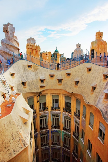 Dach mit Schornsteinen und Touristen im Gebäude Casa Mila in Barcelona in Spanien. Auch als La Pedrera oder Miracle Home oder The Quarry bezeichnet. Entworfen von Antoni Gaudí