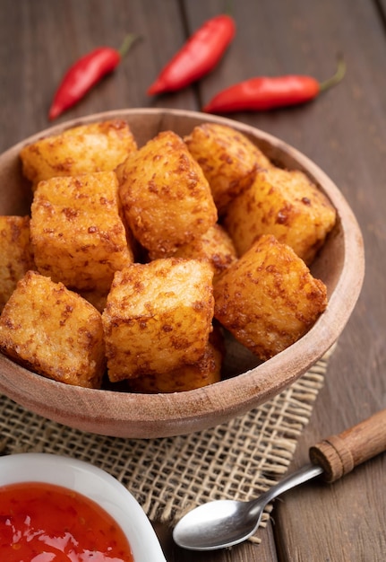 Dados de tapioca comida típica do nordeste brasileiro com calda de pimenta malagueta sobre mesa de madeira