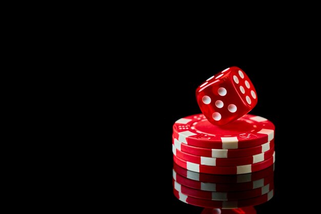 Dados y fichas de casino rojo aislado sobre fondo reflectante negro