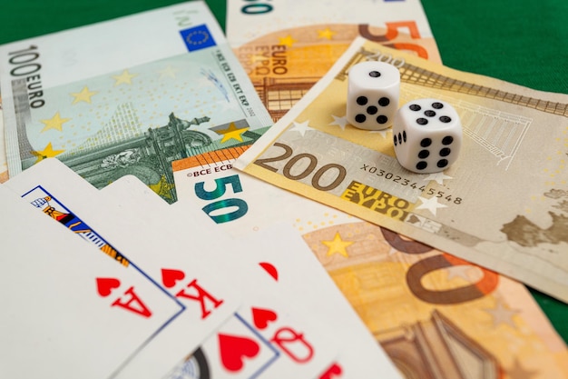 dados jogando cartas em um pano verde em notas de dólares e euros de um cassino