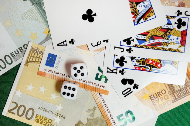 Dados jugando a las cartas sobre un paño verde en un casino dólares y billetes de euro