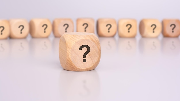 Los dados de madera con marcas de pregunta son un símbolo de incertidumbre, investigación y exploración