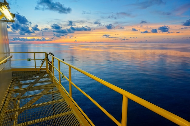 Dämmerungshimmel während Sonnenuntergangansicht von der Offshoreöl-Ölplattform mit dunkelblauem Meerwasser.