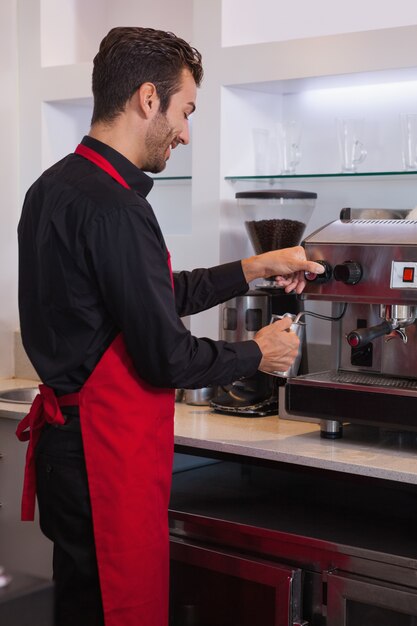 Dämpfender Krug Milch des glücklichen jungen barista