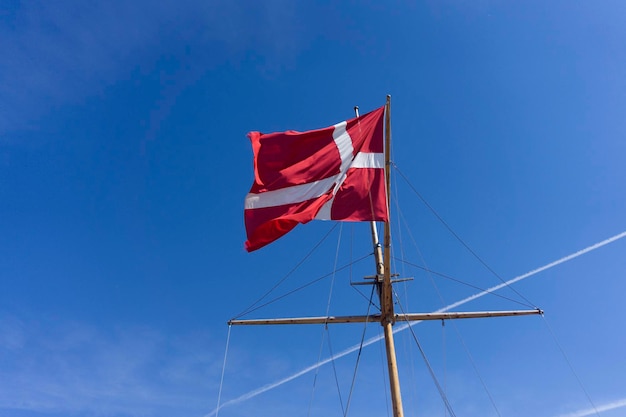 Dänemark-Flagge auf einem Schiffsmast waivng vor einem strahlend blauen Himmel