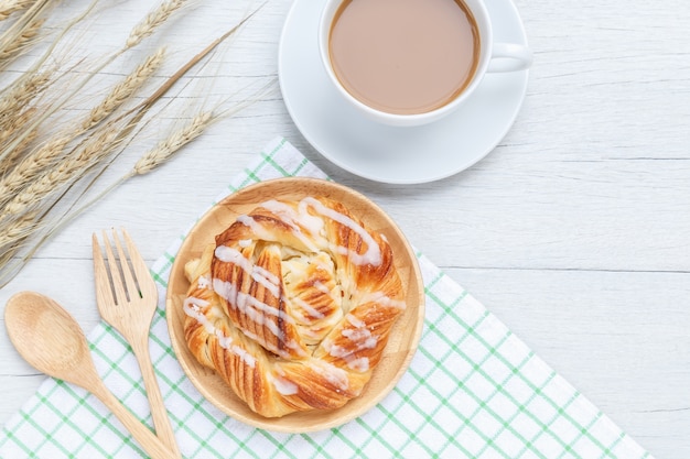 Dänisches Gebäck und Kaffeetasse der Draufsicht auf weißem Holztischhintergrund