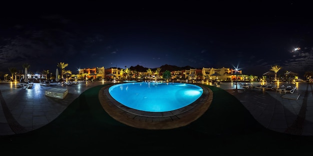 DAHAB EGIPTO DICIEMBRE 2021 Panorama nocturno hdr 360 esférico completo sin fisuras cerca de la piscina iluminada en el territorio del hotel de élite en el desierto a orillas del Mar Rojo en concepto de proyección equirectangular VR