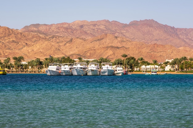 DAHAB EGIPTO DICIEMBRE 2022 vista panorámica del Mar Rojo con filas de ricos yates con montañas en el fondo