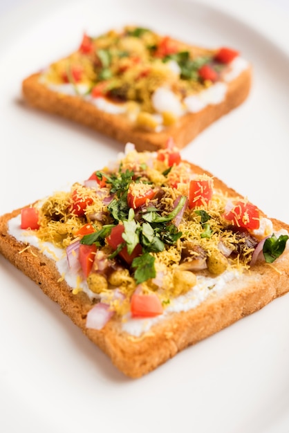 Dahi Bread papdi chaat, chat é uma entrada ou aperitivo saboroso da Índia, servido em um prato decorado com tomate, sete e coentros e masala. foco seletivo