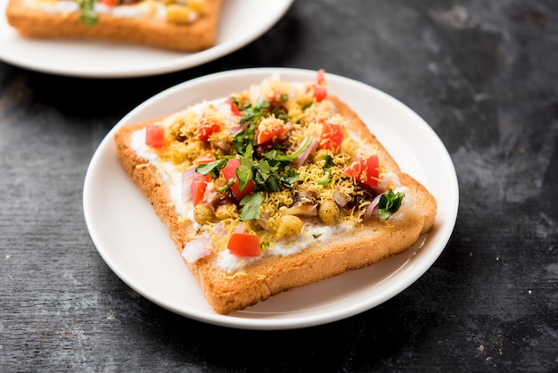 Dahi Bread papdi chaat, chat é uma entrada ou aperitivo saboroso da Índia, servido em um prato decorado com tomate, sete e coentros e masala. foco seletivo