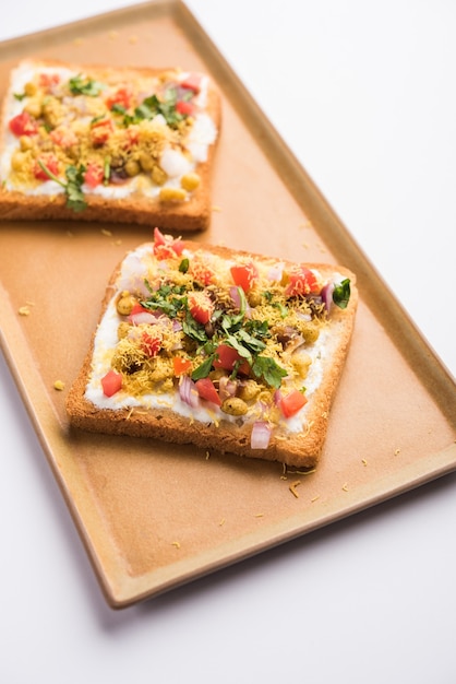 Dahi Bread papdi chaat, chat é uma entrada ou aperitivo saboroso da Índia, servido em um prato decorado com tomate, sete e coentros e masala. foco seletivo