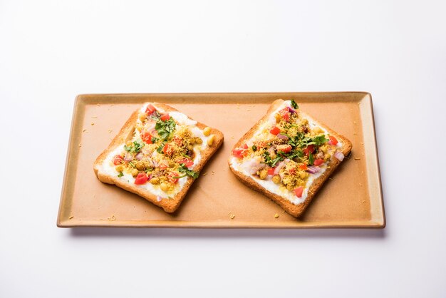 Dahi Bread papdi chaat, chat es un delicioso entrante o aperitivo de la India, que se sirve en un plato adornado con tomate, sev, cilantro y masala. enfoque selectivo