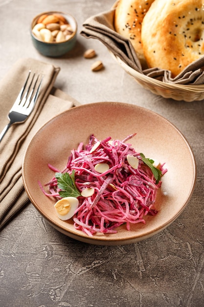 Daikon-Rüben-Salat mit Mayonnaise oder Joghurt, garniert mit Mandeln und Wachteleiern